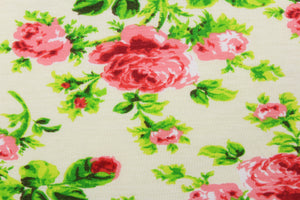 This jersey fabric features a floral design in pink, red, green, and off white. 