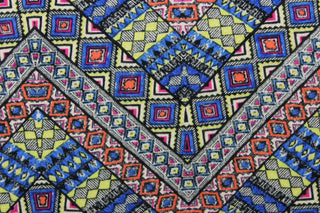 This jersey fabric features a Aztec geometric design in orange, neon yellow, black, hot pink and blue.