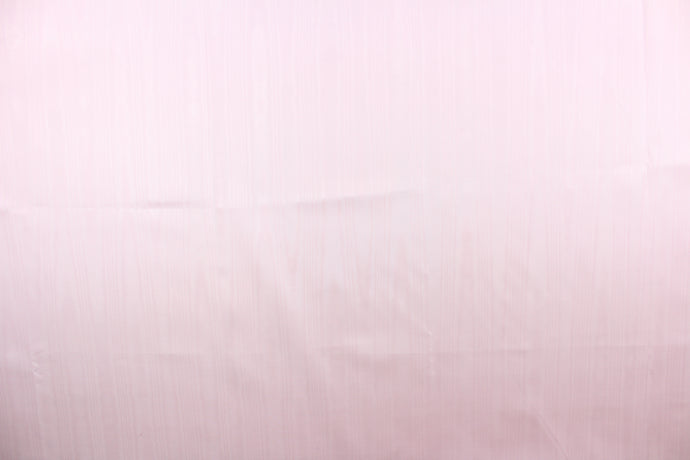 This taffeta fabric in a solid in soft pink. This fabric has a slight shine and a wavy, watery look.