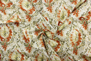  This fabric features a damask design in green, orange, beige, pale yellow, gray, and white . 