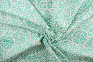 This fabric features a medallion design in turquoise and white. 