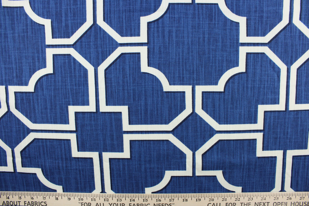 This fabric features a geometric design in white with black outline against a blue background.