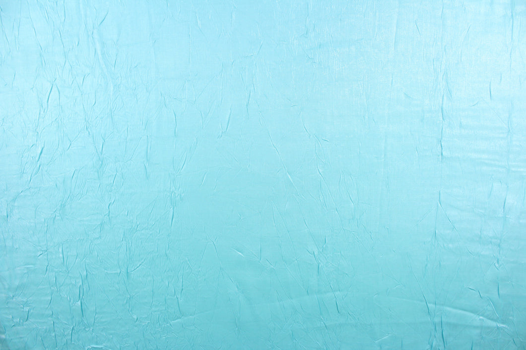 This taffeta fabric features a crinkle in iridescent in a light turquoise blue.