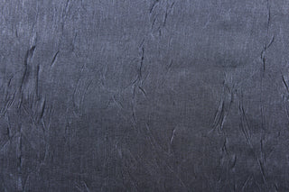 This taffeta fabric features a crinkle in iridescent in a dark gray blue . 