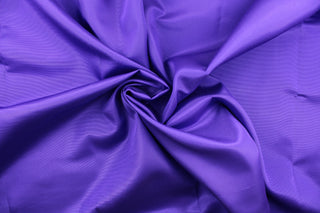 This bengaline faille fabric in a solid violet purple. This fabric has a slight shine and a slight ribs in the weft.