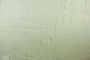 This taffeta fabric features a crinkle in iridescent pale green. 
