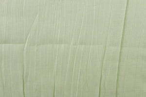 This taffeta fabric features a crinkle in iridescent pale green. 