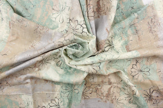 This fabric features a floral design in black, beige, brown, off white, seafoam green, and gray with hints of silver.