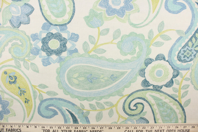 This fabric features a floral paisley design in turquoise, seafoam green, lime green, blue, teal, and natural. 