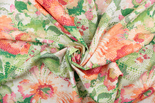 This fabric features a floral design in bright orange, pink, peach, green, hot pink, lime green, and white. 