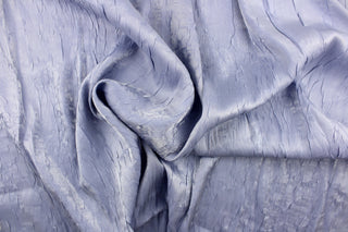 This taffeta fabric features a crinkle in iridescent silver blue color.