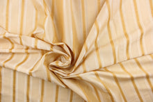 Load image into Gallery viewer, This stunning yarn dyed fabric features a striped pattern in light beige, with gold and champagne stripes . 
