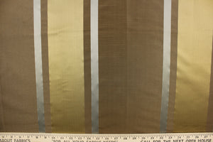 This stunning yarn dyed fabric features a striped pattern in brown, gray and gold. Enhancing the various colors of the stripes is a slight sheen.