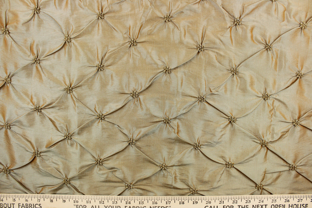 This beautiful fabric features an embroider gathered design in a iridescent gold with aqua undertones .