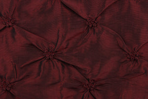 This beautiful fabric features an embroider gathered design in a iridescent deep red with black undertones .