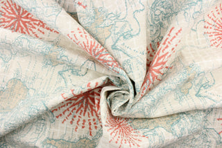 This chenille fabric features a world map with an oversized compass in blue, coral and off white
