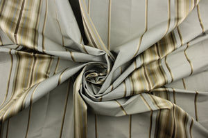 This stunning yarn dyed fabric features a multi width striped pattern in gray, brown, gold, and shades of khaki. Enhancing the various colors of the stripes is a slight sheen.