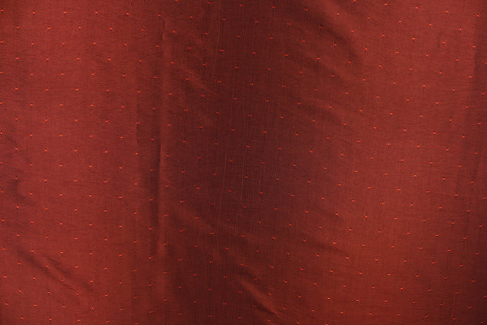 This beautiful jacquard fabric features an embroider pin head design in a rich iridescent red tone.