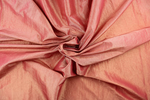 This taffeta fabric features a crinkle in iridescent coral pink with hints of gold. 