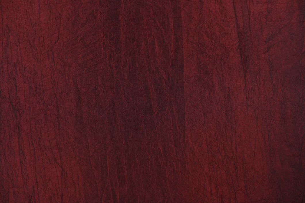 This taffeta fabric features a crinkle in iridescent deep red.