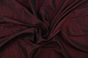 This taffeta fabric features a crinkle in iridescent dark burgundy. 
