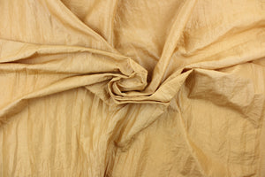 This taffeta fabric features a crinkle design in gold. 