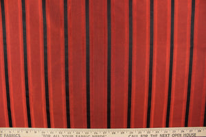 This stunning yarn dyed fabric features a striped pattern in a rich red and black.