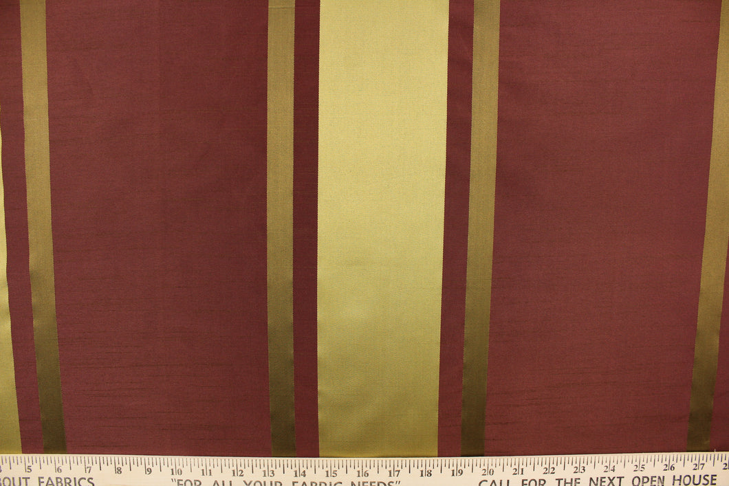 This stunning yarn dyed fabric features a  striped pattern in plum and gold tones.