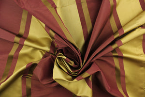 This stunning yarn dyed fabric features a  striped pattern in plum and gold tones.
