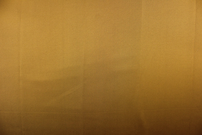 This beautiful versatile fabric offers a slight sheen in a solid dark gold .