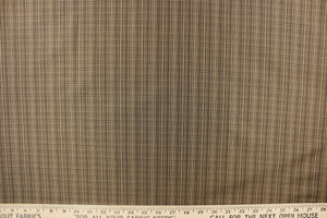 This stunning yarn dyed fabric features a small plaid design in shades of brown with hints of gray. 