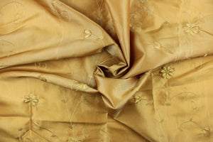 This beautiful jacquard fabric features an embroider floral  design in a golden tan