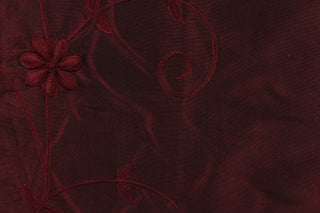 This beautiful fabric features an embroider floral design in a iridescent red wine color