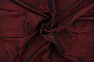 This beautiful fabric features an embroider floral design in a iridescent red wine color