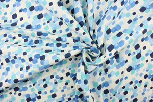 This fabric features a fun geometric design in shades of blue on a off white background.
