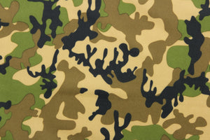 This fabric features a camo pattern in green, black, brown and beige.