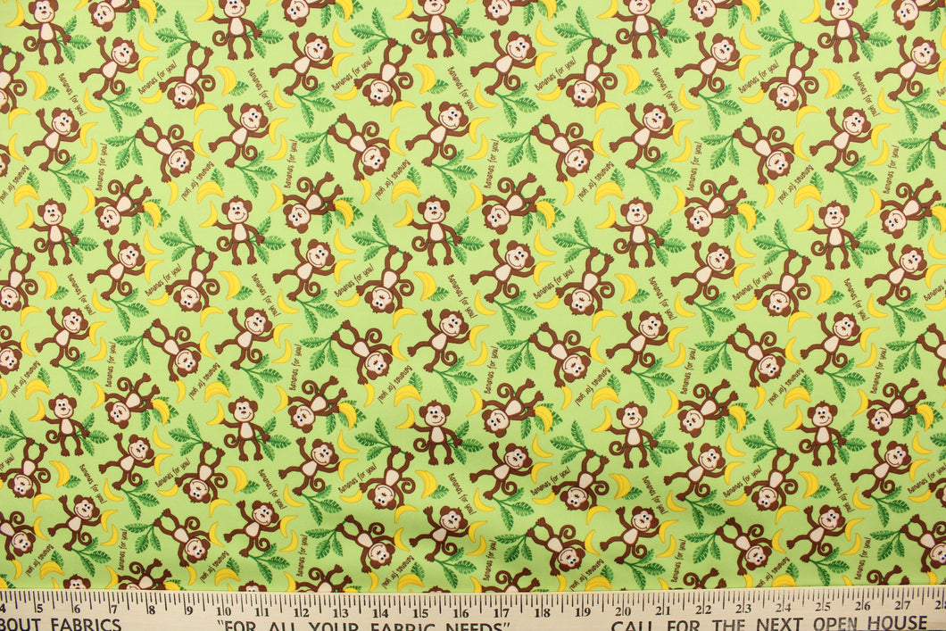  This cute playful print features monkeys with bananas on a light green background.