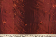 Load image into Gallery viewer, This beautiful fabric features an embroider floral design in a iridescent rustic red .
