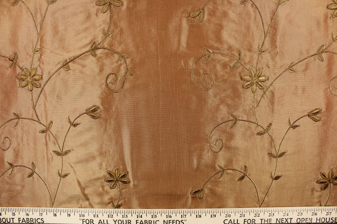This beautiful fabric features an embroider floral design in a iridescent gold. 