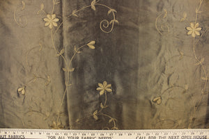  This beautiful fabric features an embroider floral design in a iridescent dark olive green