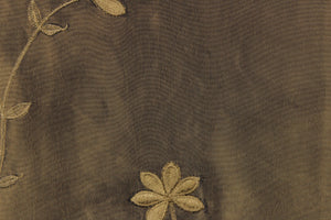  This beautiful fabric features an embroider floral design in a iridescent dark olive green
