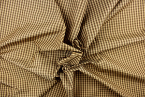 This yarn dye stripe fabric features a small plaid or checkered design in brown and tan. 