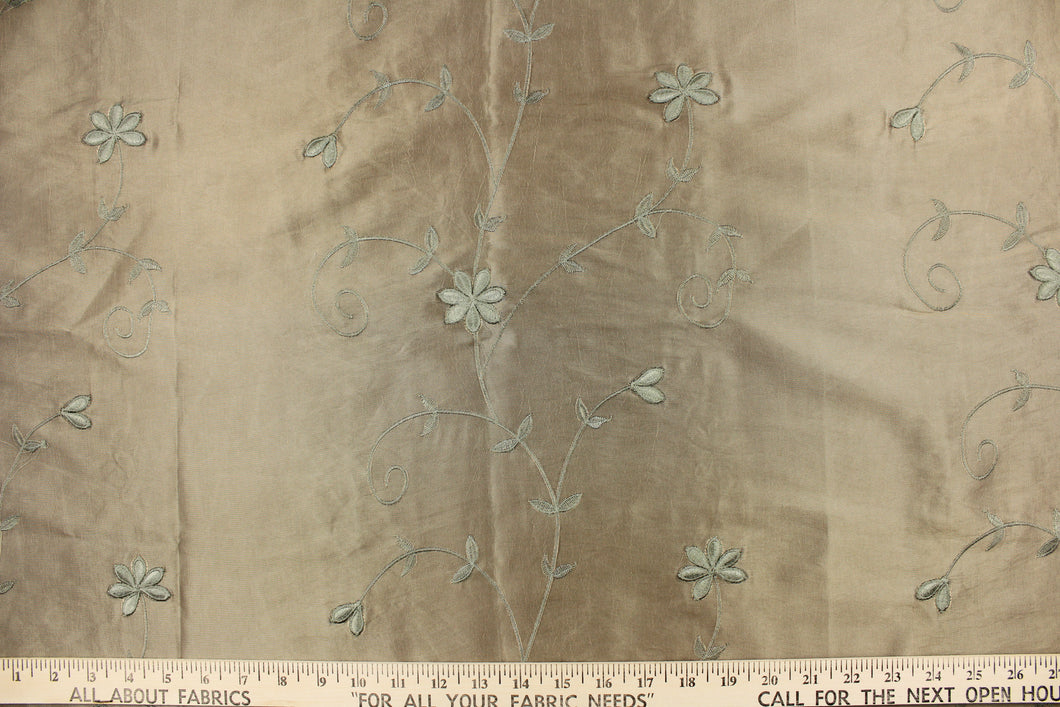 This beautiful jacquard fabric features an embroider floral design in a olive green tone. 