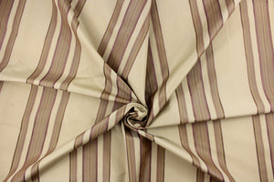 This fabric features a multi width stripe design in khaki, beige and purple.