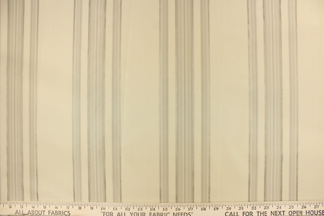 This fabric features a multi width stripe design in khaki, and beige. 