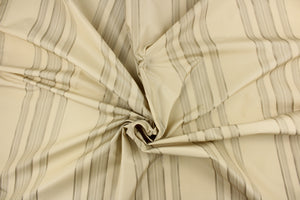 This fabric features a multi width stripe design in khaki, and beige. 