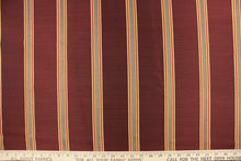 Load image into Gallery viewer, This rich woven yarn dyed fabric features bold multi width striped design in a rich wine red, taupe, and gold. 
