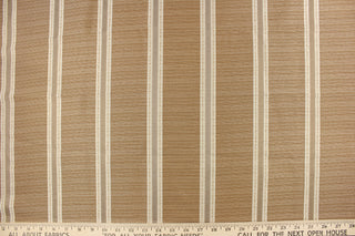 This rich woven yarn dyed fabric features bold multi width striped design in gold, cream, and champagne. 