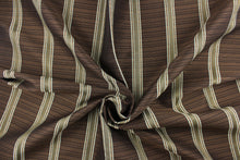 Load image into Gallery viewer, This rich woven yarn dyed fabric features bold multi width striped design in light blue, dark brown and copper. 
