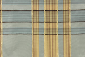 This fabric features a plaid design in blue gray, beige, tan, dark brown and light gold.